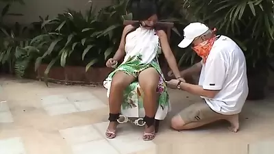 Asian teen tied up and hand cuffed on a chair